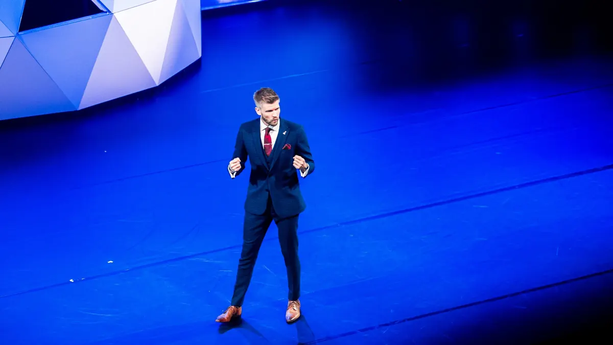Bart Grootveld spreekt op een blauw verlicht podium